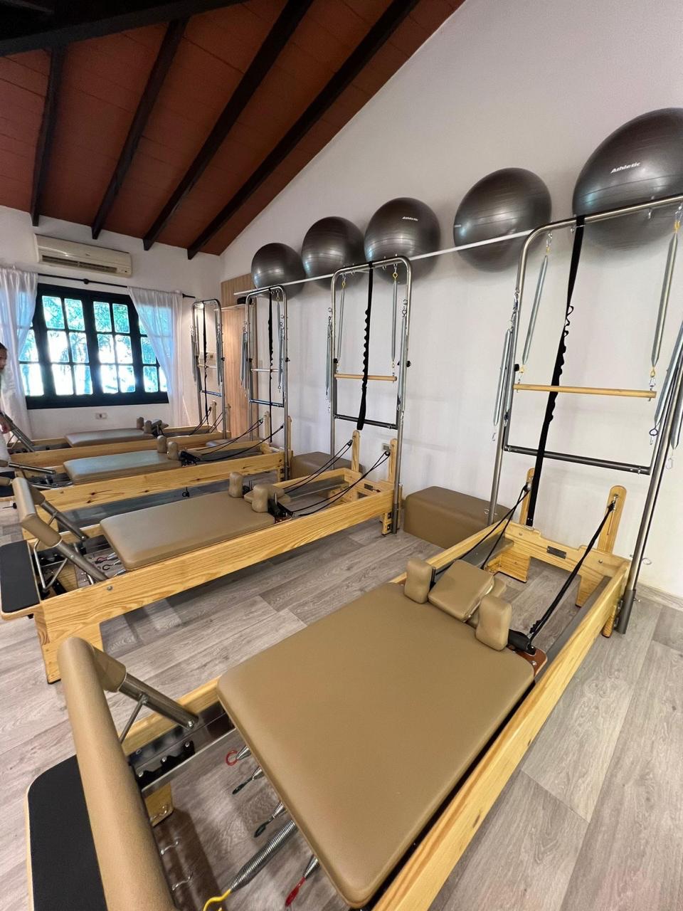 Reformers de madera con torre y tapizado camel en un estudio