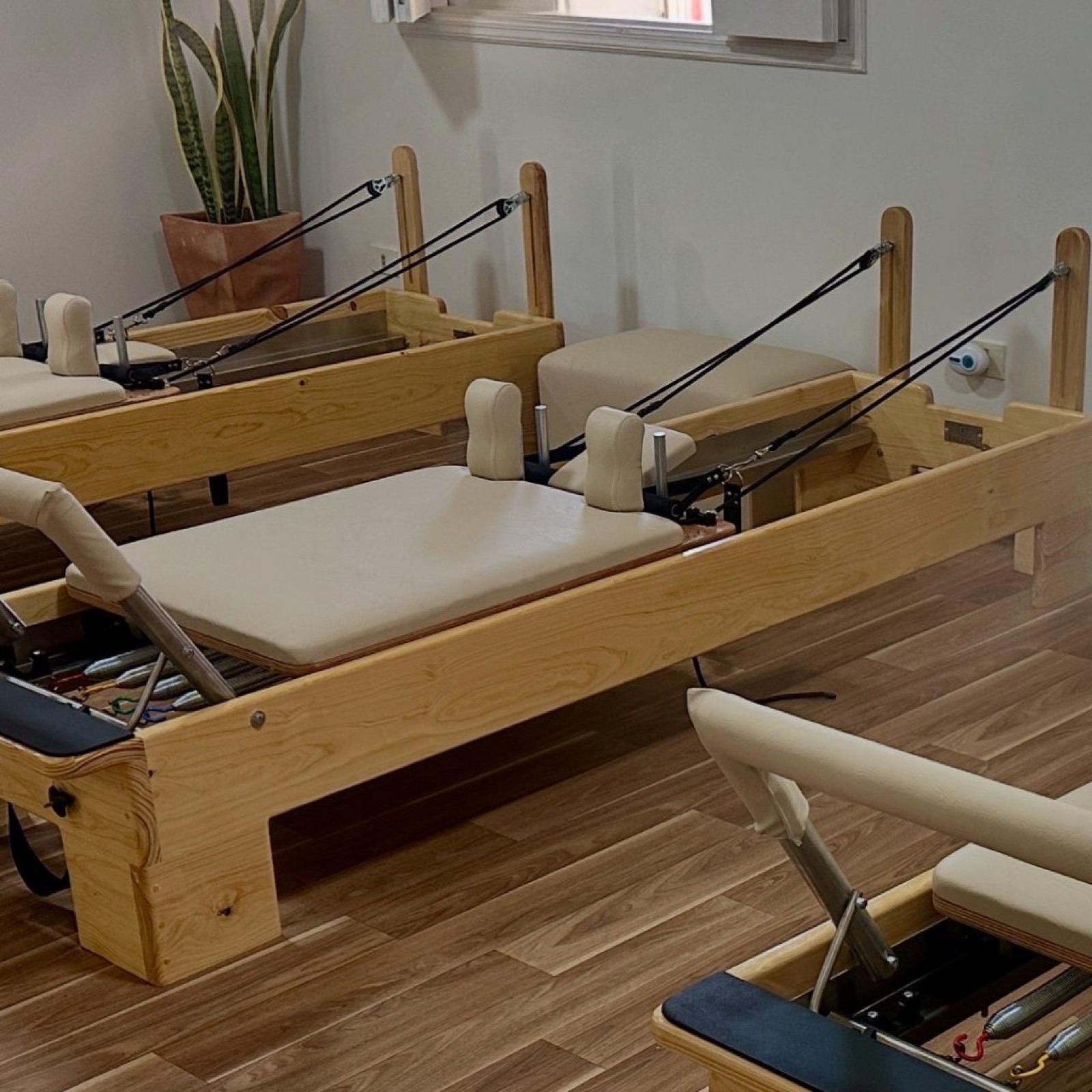 Reformer de madera guatambú con tapizado cream en estudio